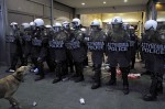 A dog barks at riot police in front of the finance ministry
